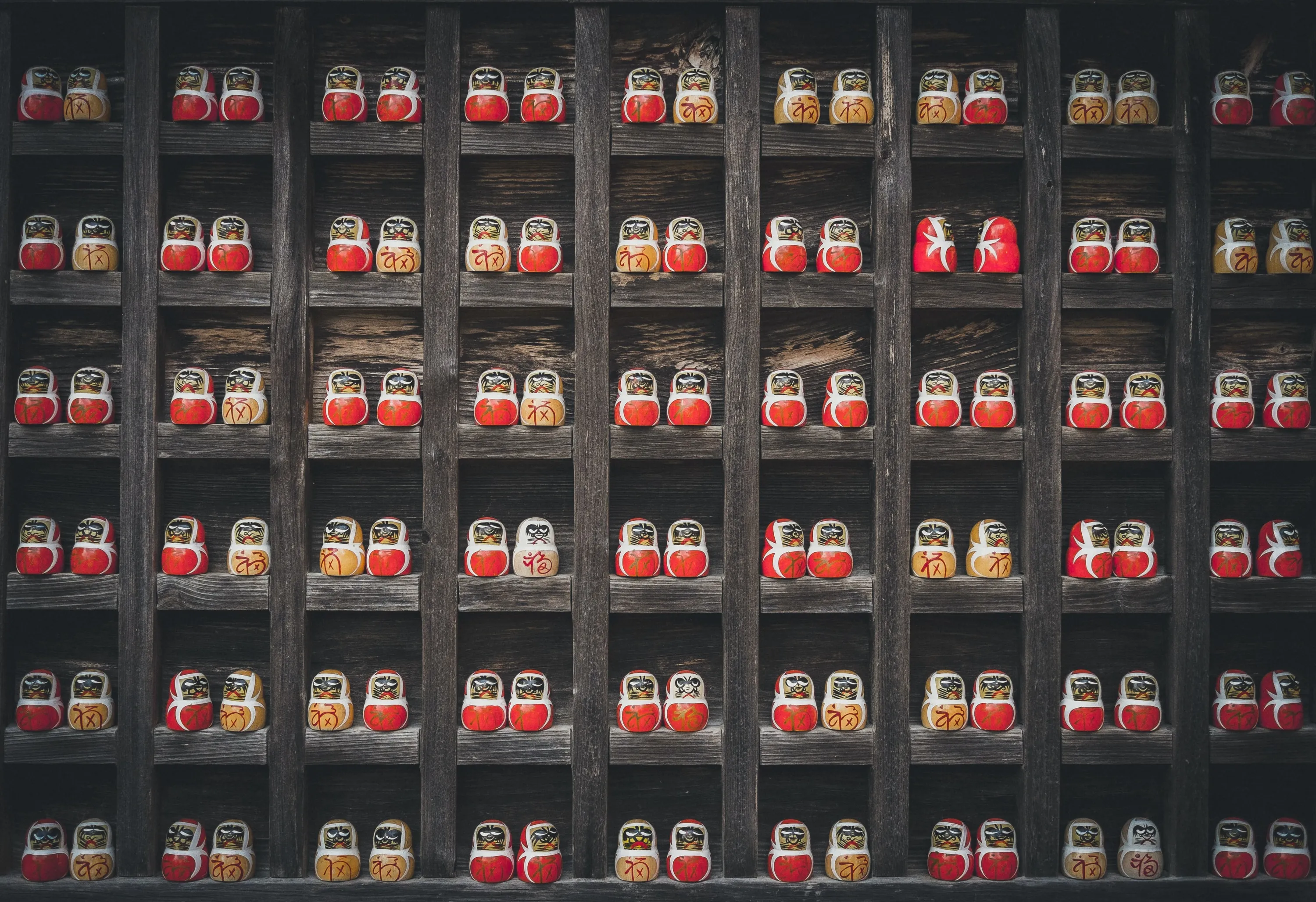 A wall with standing matryoshka dolls