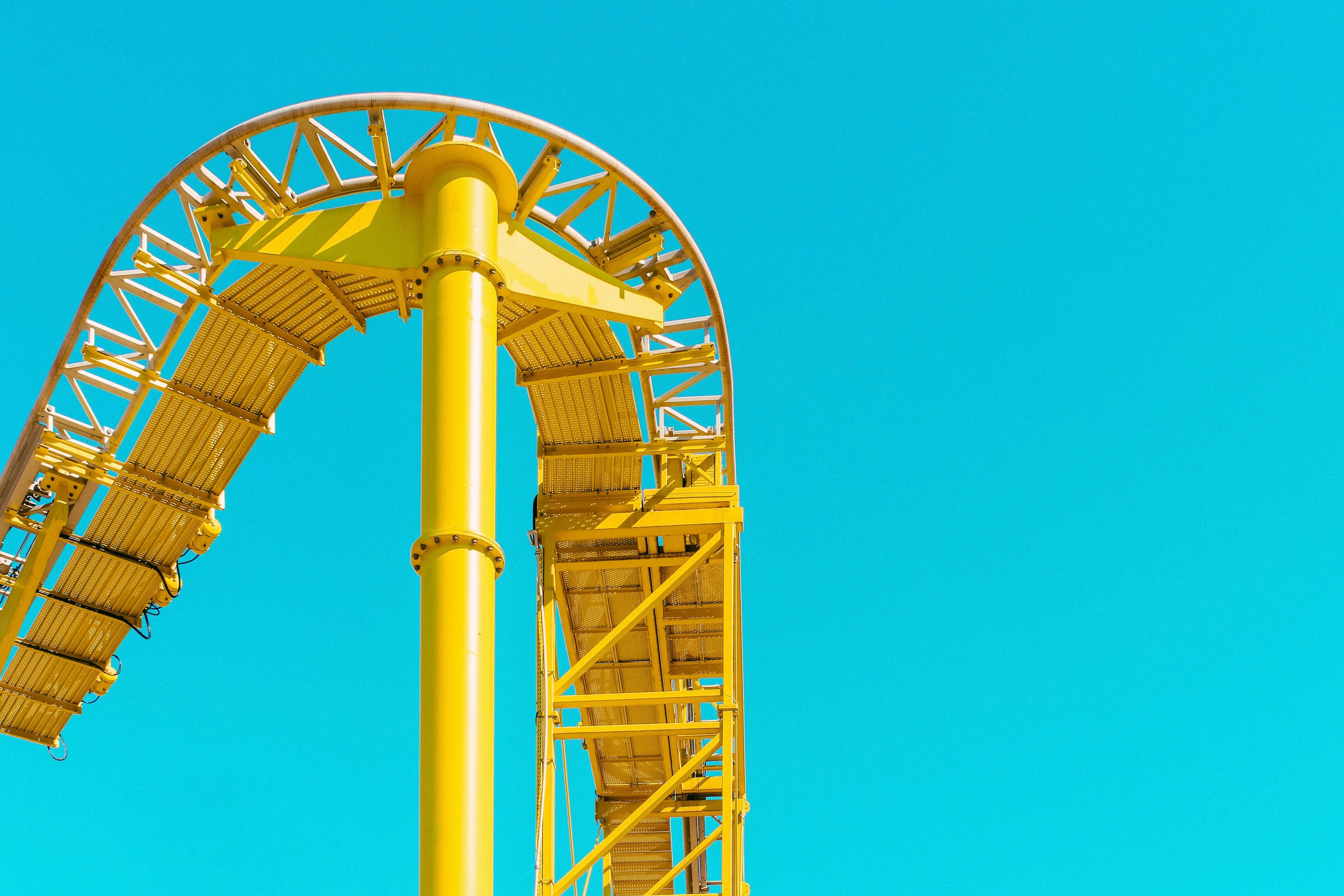 A yellow rollercoaster ride with a blue sky